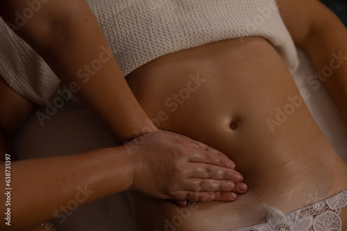 Relaxed girl getting belly massage in salon top view
