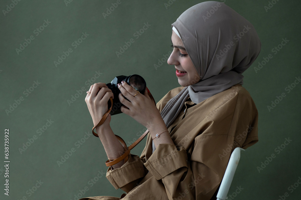 Pretty Muslim girl in hijab holding vintage camera over background in ...