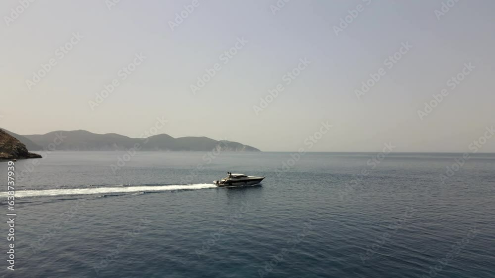 Boat leaves the coast of Kefalonia in Greece, beautiful summer day, aerial Boat leaves the coast of Kefalonia in Greece, beautiful summer day, aerial