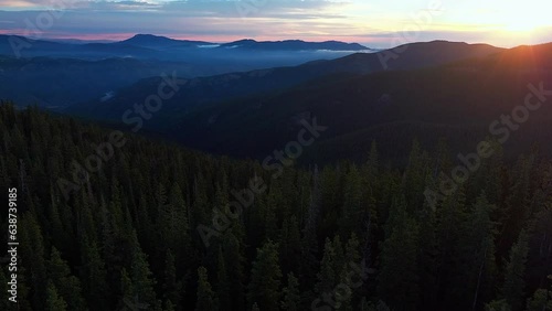 Cinematic aerial drone sunrise morning sun flare fog Denver front range foothills Rocky Mountains layers i70 Idaho Springs Evergreen Mount Evans 14er wilderness Squaw pass Echo Mountain backwards pan photo