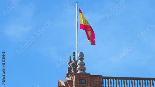 Spanish flag waving on top of one of the towers of Plaza de España in Seville