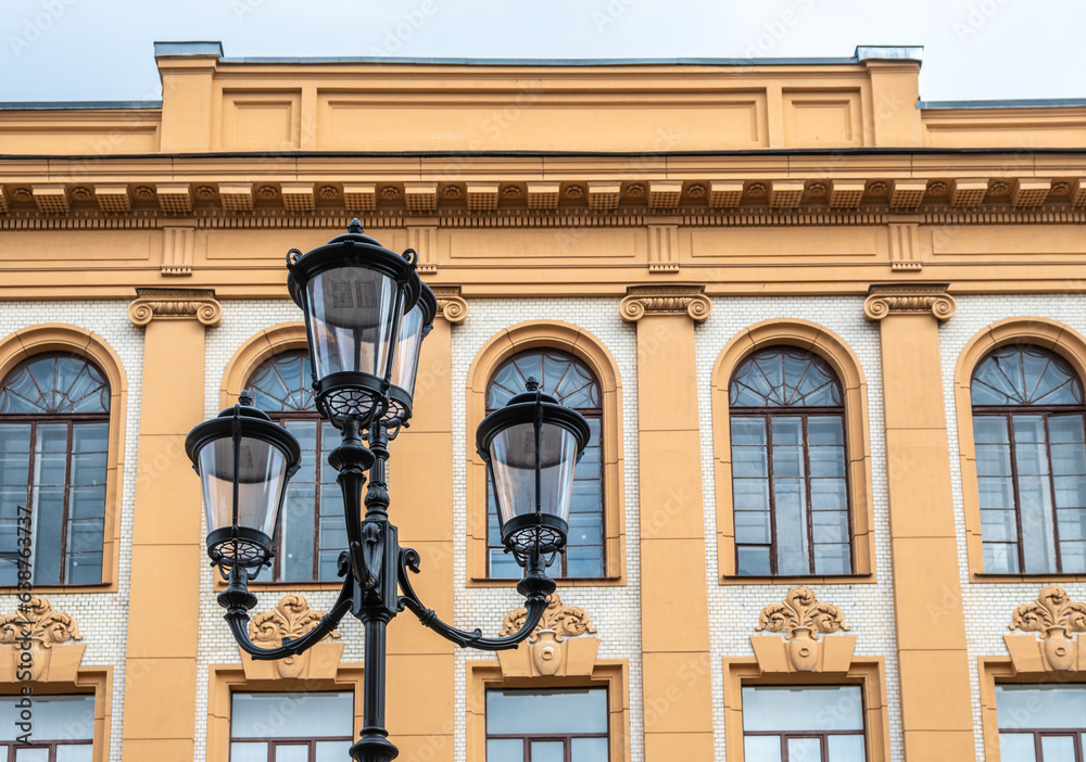 An old lighting pole on the background of an old building. An old lighting pole on the background of an old building.