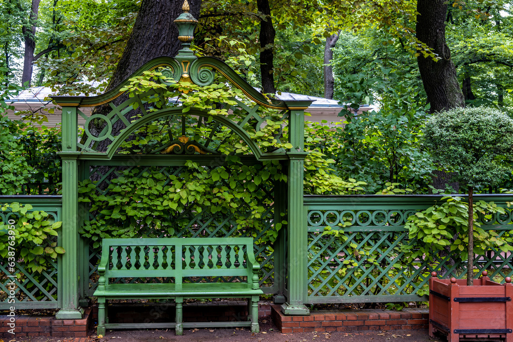 A wooden bench in the park among the greenery. A wooden bench in the park among the greenery.