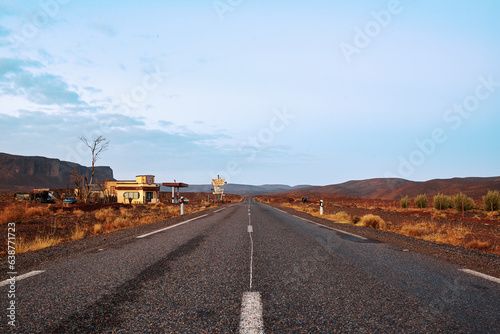 road to nowhere in the desert, with old gas station on the left 