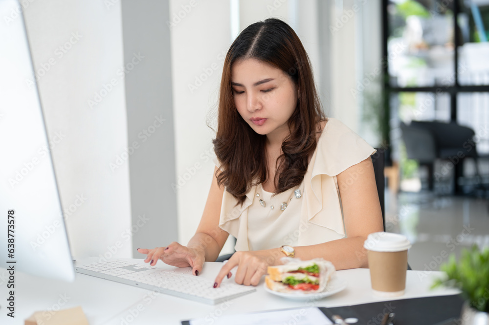 A hardworking Asian business woman is working on her assignment on computer A hardworking Asian business woman is working on her assignment on computer