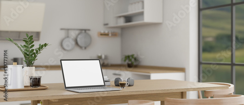 Close-up image of a laptop mockup on a wooden dining table in a minimalist, Scandinavian kitchen.