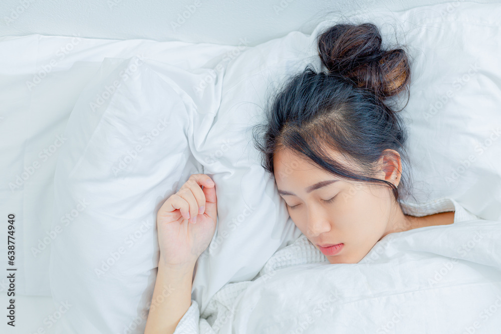 Young woman sleeping in a white blanket in the bright morning Young woman sleeping in a white blanket in the bright morning