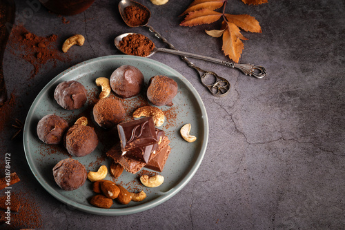 Pieces of chocolate and nuts in a plate on a dark background