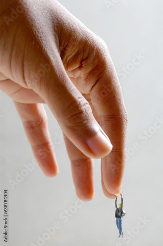 Miniature People Hanging on Hand