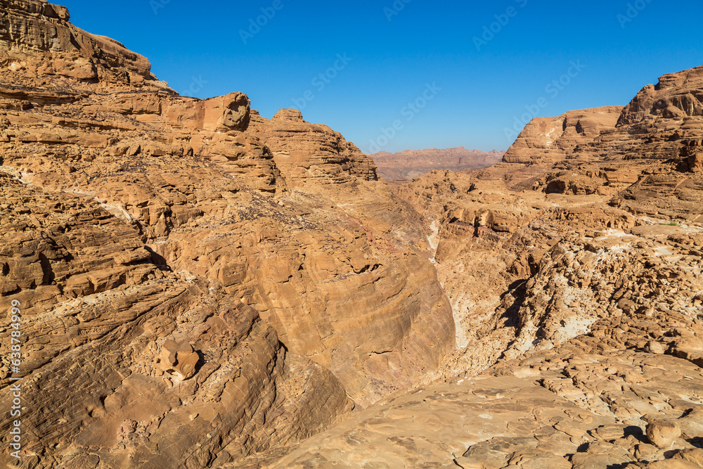 Sinai desert. Yellow and orange sandstone textured carved mountain, bright blue sky. Egyptian desert landscape