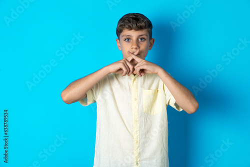 Beautiful kid boy wearing casual shirt Has rejection angry expression crossing fingers doing negative sign.
