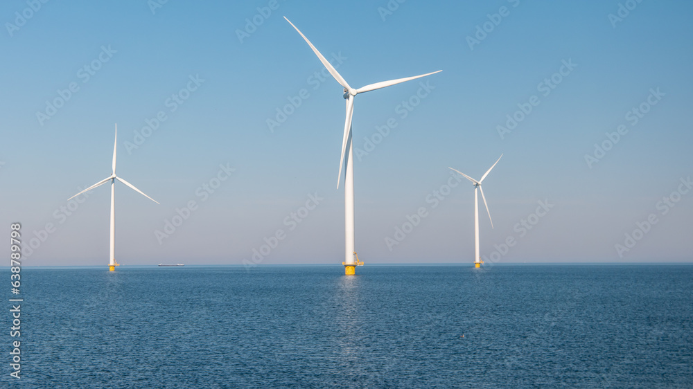 offshore windmill park with clouds and a blue sky, windmill park in the ocean aerial view of wind turbine Flevoland Netherlands Ijsselmeer. Green energy 