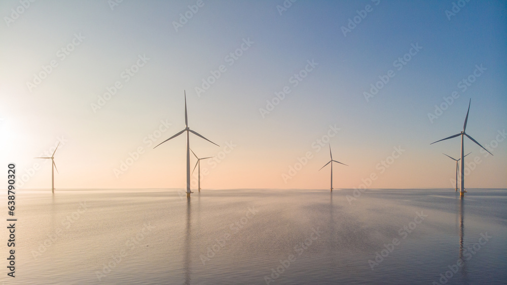 offshore windmill park, windmill park in the ocean aerial view with wind turbine Flevoland Netherlands Ijsselmeer. Green energy during sunset