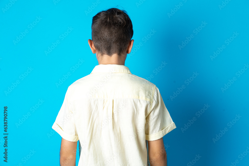 The back view of a Beautiful kid boy wearing casual shirt . Studio Shoot. The back view of a Beautiful kid boy wearing casual shirt . Studio Shoot.