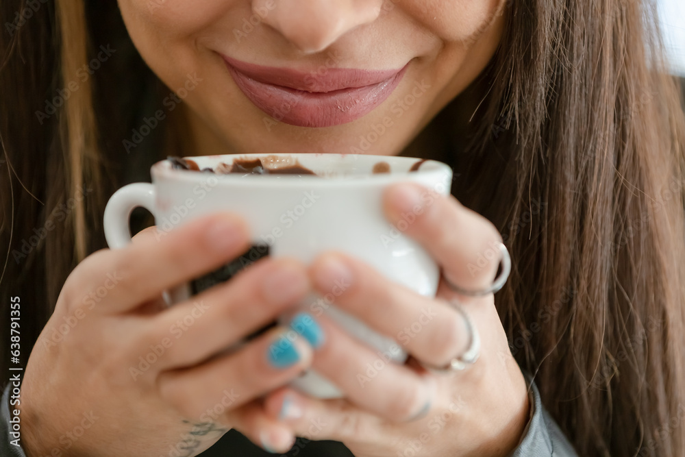 Brunette woman in a cafe drinking coffee and chocolate happy, content and relaxed Brunette woman in a cafe drinking coffee and chocolate happy, content and relaxed