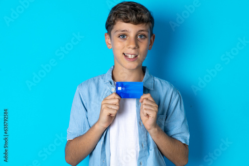 Photo of Beautiful kid boy wearing casual clothes positive smile hold credit card income salary