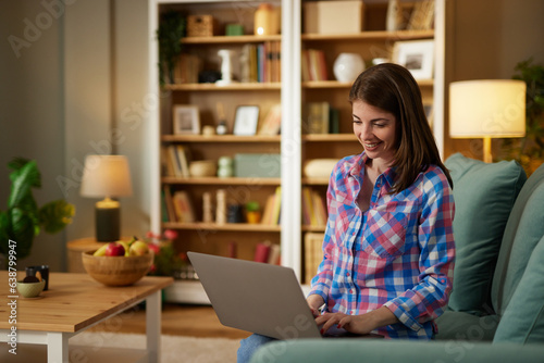 Young smiling woman working remotely from home on laptop