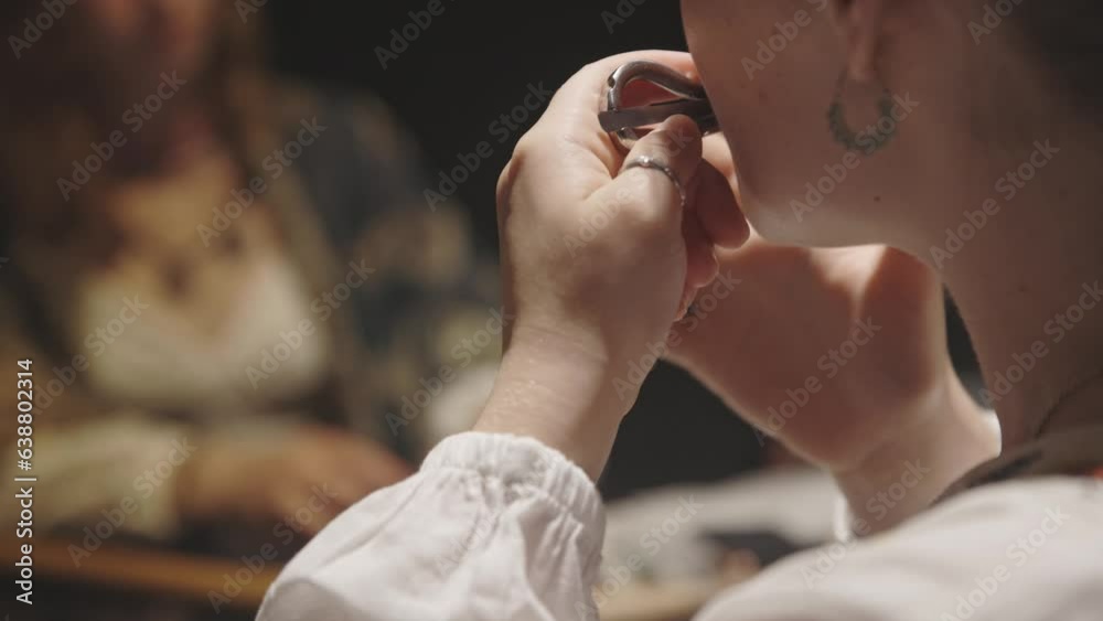 A young woman playing jaw harp in the circle of musicians A young woman playing jaw harp in the circle of musicians