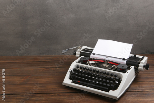 vintage typewriter on the table with blank paper on wooden desk - concept for writing, journalism, blogging