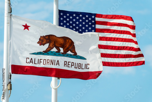 California Republic bear flag and US american flags floating on poles side by side photo