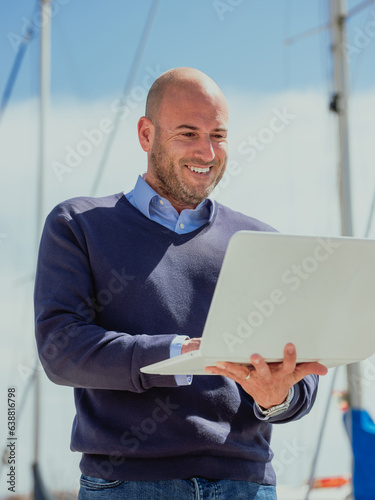 Businessman standing outside looking at the laptop