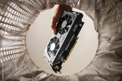 Canvastavla throwing a video card in the trash bin, a computer video card in hand inside view trash bin