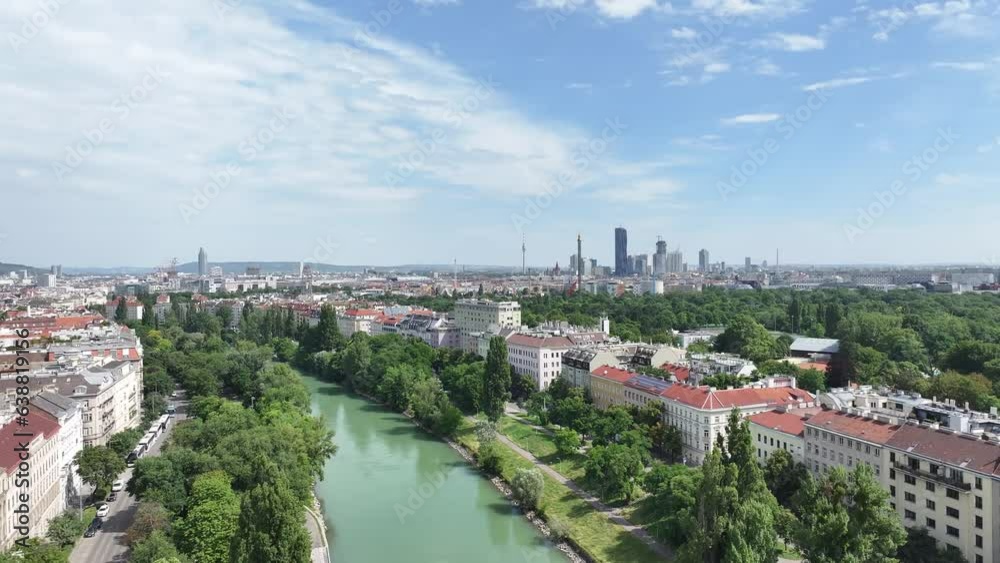 Drone pull back above river in Vienna, Austria. Down town skyscrapers on horizon. Sunny day. Drone pull back above river in Vienna, Austria. Down town skyscrapers on horizon. Sunny day.