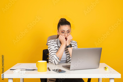 Worried business woman employee, portrait of young caucasian brunette worried business woman employee. Sit work office desk using laptop pc computer. Business career concept. Gnawing nails.