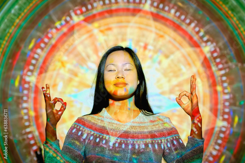 Asian woman meditating near mandala