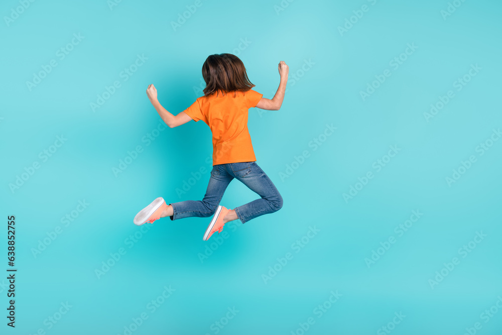 Back rear view photo of overjoyed girl wear trendy orange outfit hand fist success sale empty space isolated on cyan color background