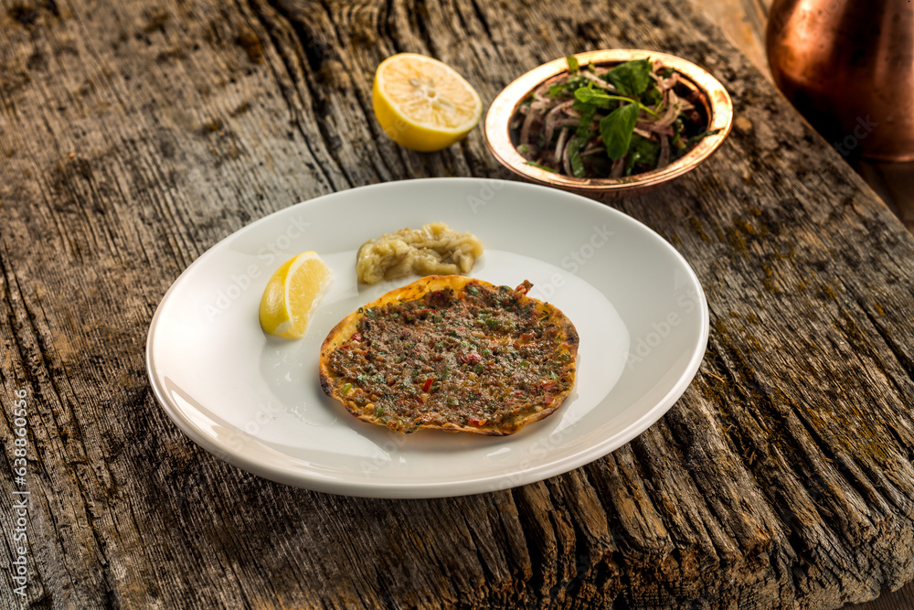 Delicious crunchy small bread with meat with vegetables on a plate
wooden background Delicious crunchy small bread with meat with vegetables on a plate
wooden background