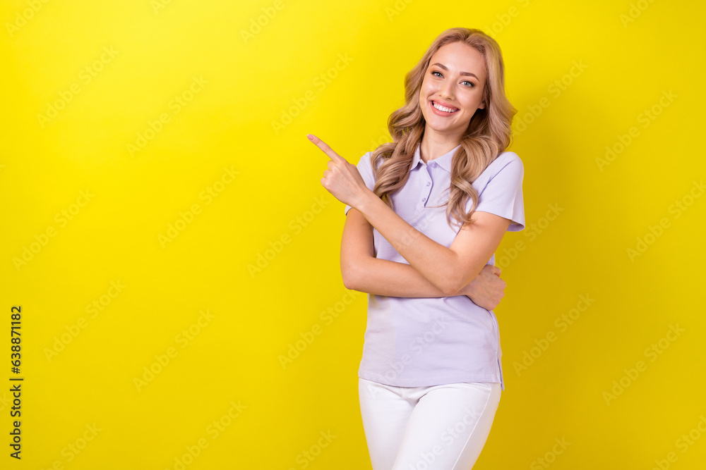 Photo of pretty cheerful woman dressed violet t-shirt pointing finger empty space isolated yellow color background Photo of pretty cheerful woman dressed violet t-shirt pointing finger empty space isolated yellow color background