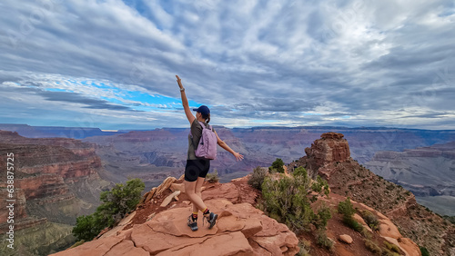Woman with scenic view from Ooh Ahh point on South Kaibab hiking trail at South Rim, Grand Canyon National Park, Arizona, USA. Colorado River weaving through valleys and rugged terrain. O Neill Butte photo