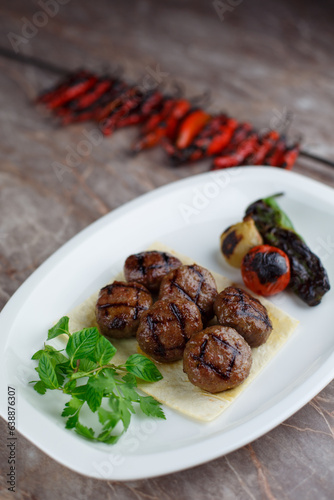 Delicious grilled meatballs with vegetables on a plate