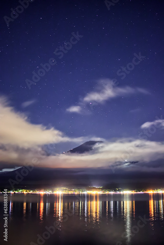 星空の下で雲に隠れる富士山と山中湖