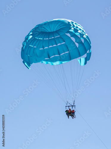 A blue parachute flies over the sea