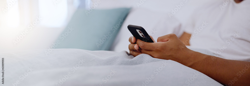 Typing, bed and hands of a man with a phone for social media, communication and chat. Contact, internet and guy scrolling on a mobile app for messages, reading emails or notification in the bedroom Typing, bed and hands of a man with a phone for social media, communication and chat. Contact, internet and guy scrolling on a mobile app for messages, reading emails or notification in the bedroom