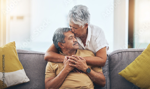 Love, kiss and senior couple on sofa for bonding, healthy marriage and relationship in living room. Retirement, hug and loving man and woman on couch embrace for trust, commitment and care at home