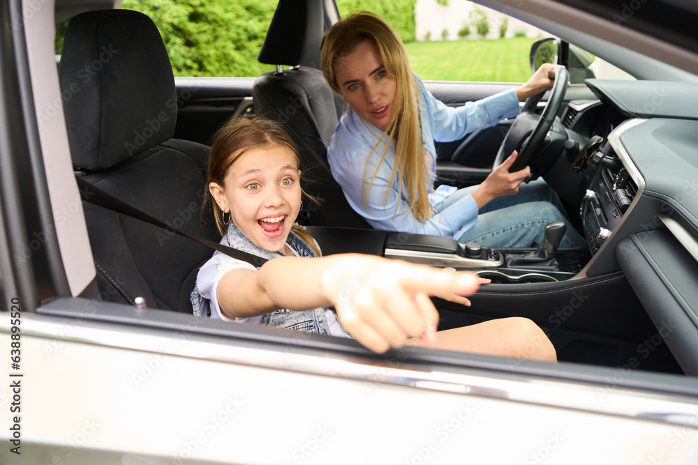 Happy little girl is pointing at something outside car window Happy little girl is pointing at something outside car window