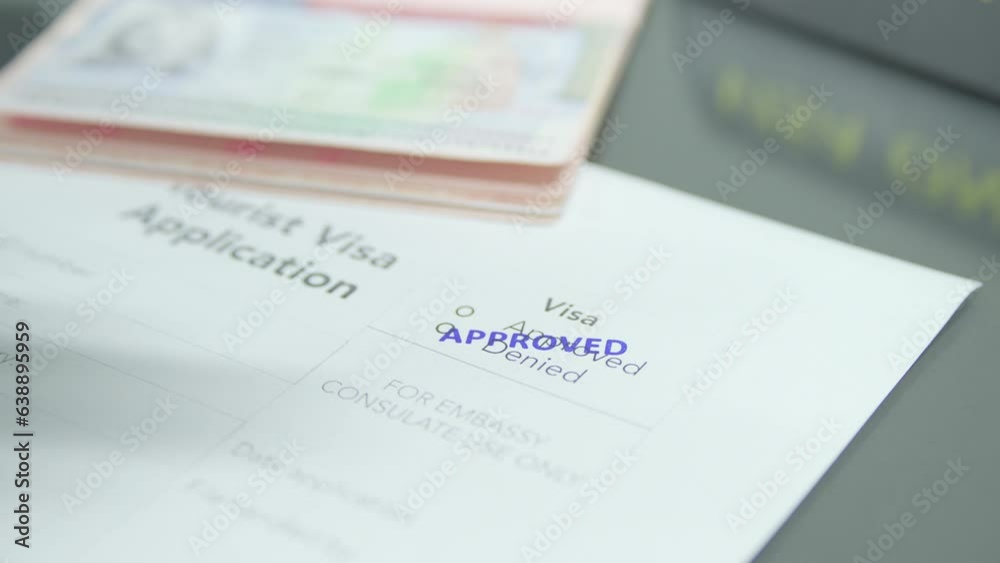 Close up putting stamp approved into visa application paper 