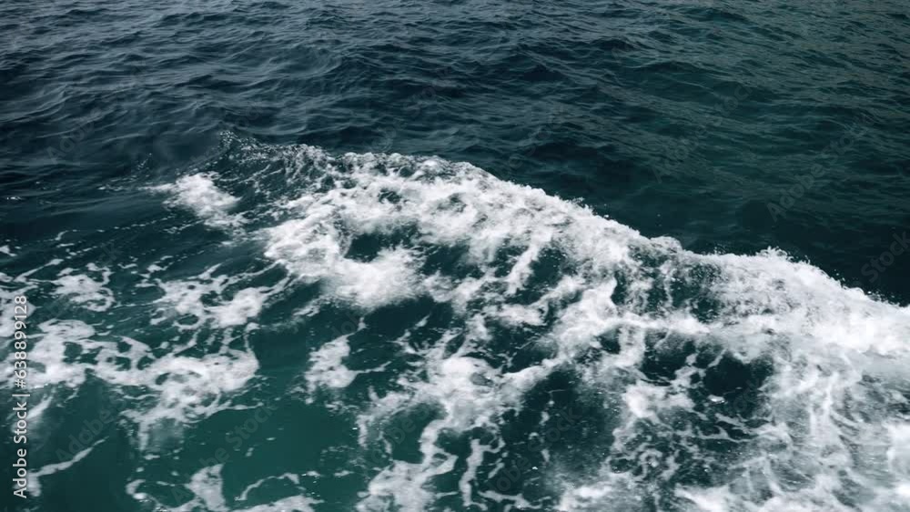 View from the ship on splashing ocean waves on cold stormy day.