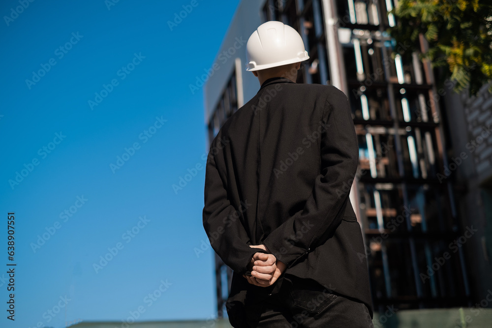 male foreman at a construction site looks at the quality of work, Architectural design holds a laptop at a construction site, checks plans. Successful engineer or architect, cheerful businessman.