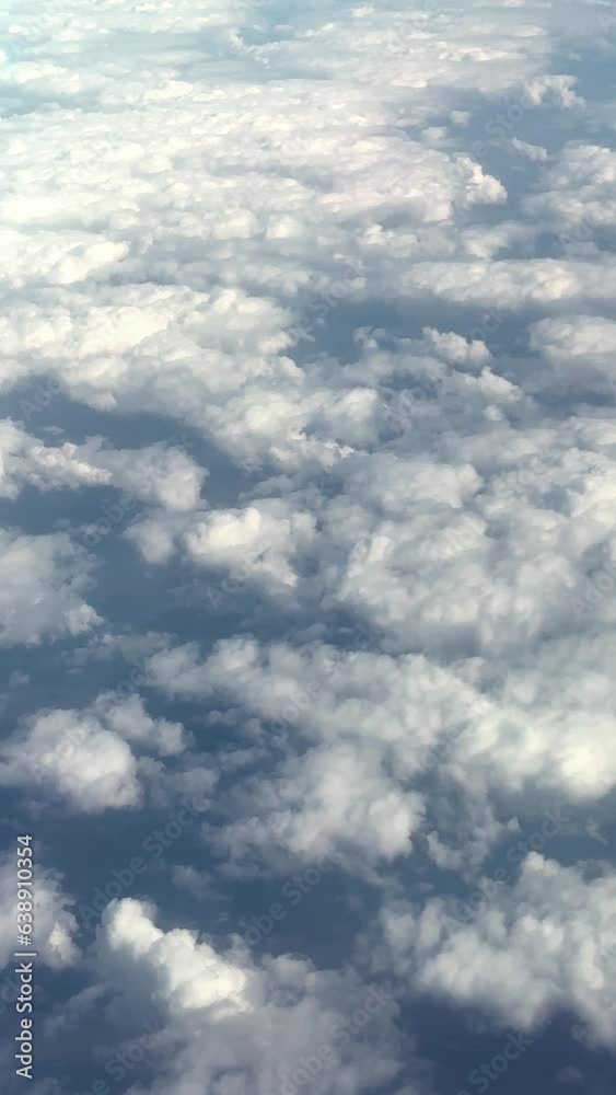 Vertical video of a view from a plane flying over puffy clouds. Aerial. Vertical video of a view from a plane flying over puffy clouds. Aerial.