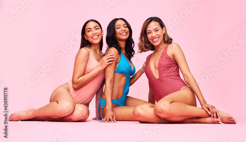 Underwear, bikini and group of happy women in studio, sitting together with smile and fun body positivity. Beauty, summer fashion and swimwear models with self love, diversity and pink background.