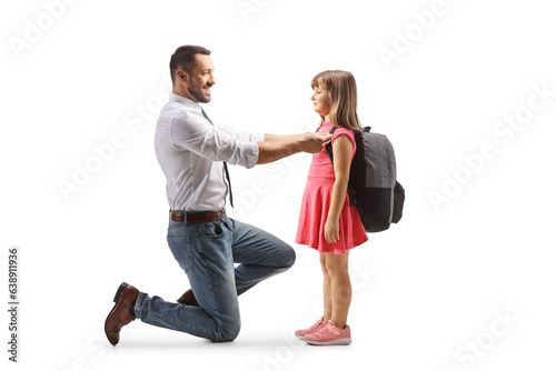 Full length profile shot of a man putting a backpack on a girl