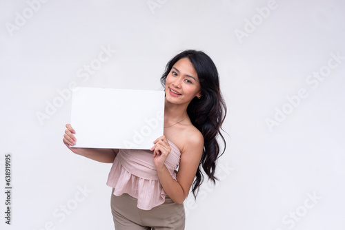 A smart young Asian woman smiling pleasantly while holding a white blank signange. Isolated on a white background.