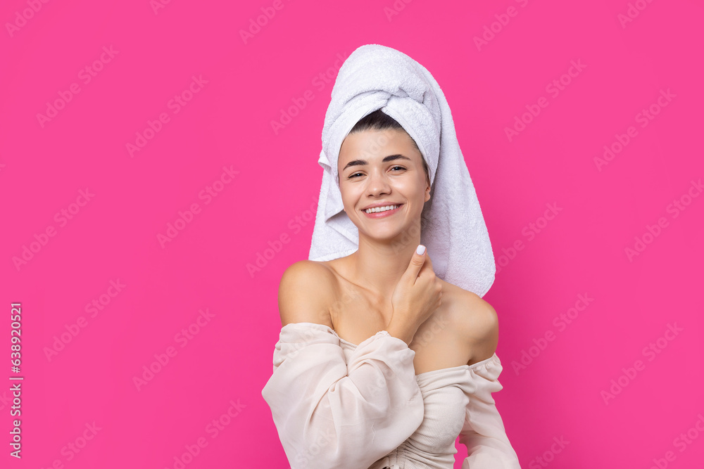 Portrait of young beautiful woman after bath. Beauty face of a cheerful attractive girl with towel on head against a pink background. Portrait of young beautiful woman after bath. Beauty face of a cheerful attractive girl with towel on head against a pink background.