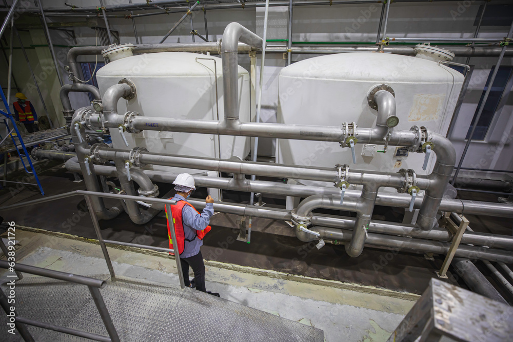 Fototapeta premium Male work operations process powder cellar at the with vertical stainless steel tanks