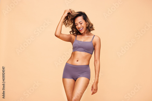 Healthy body, dance and happy woman in lingerie in studio with self love, results and skincare on wall background. Beauty, cosmetics and female model dancing for wellness, good mood or acceptance