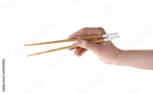 Woman holding pair of wooden chopsticks on white background, closeup